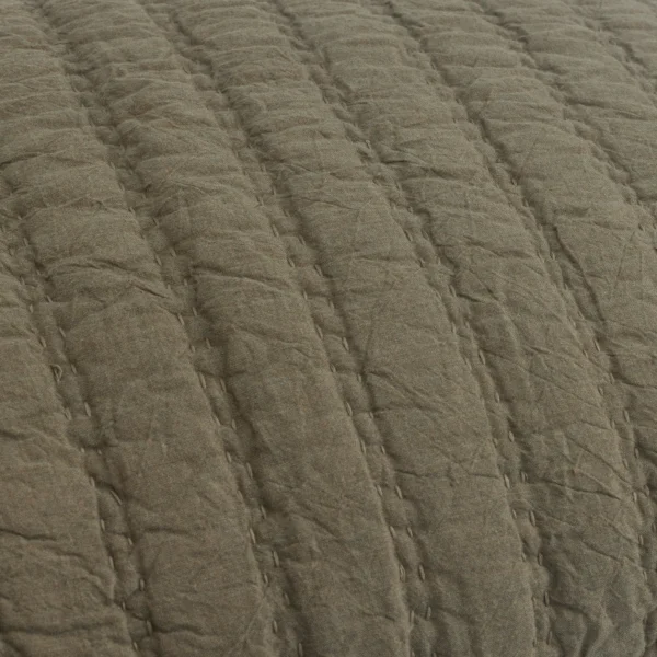 Close up of brown linen fabric with a quilted wavy pattern and raised ridges