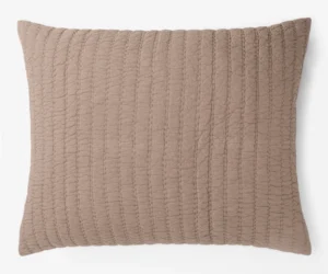 Brown quilted throw pillow with vertical stitching on a white background