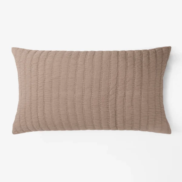 Beige quilted pillow edge with vertical stitching against a white background