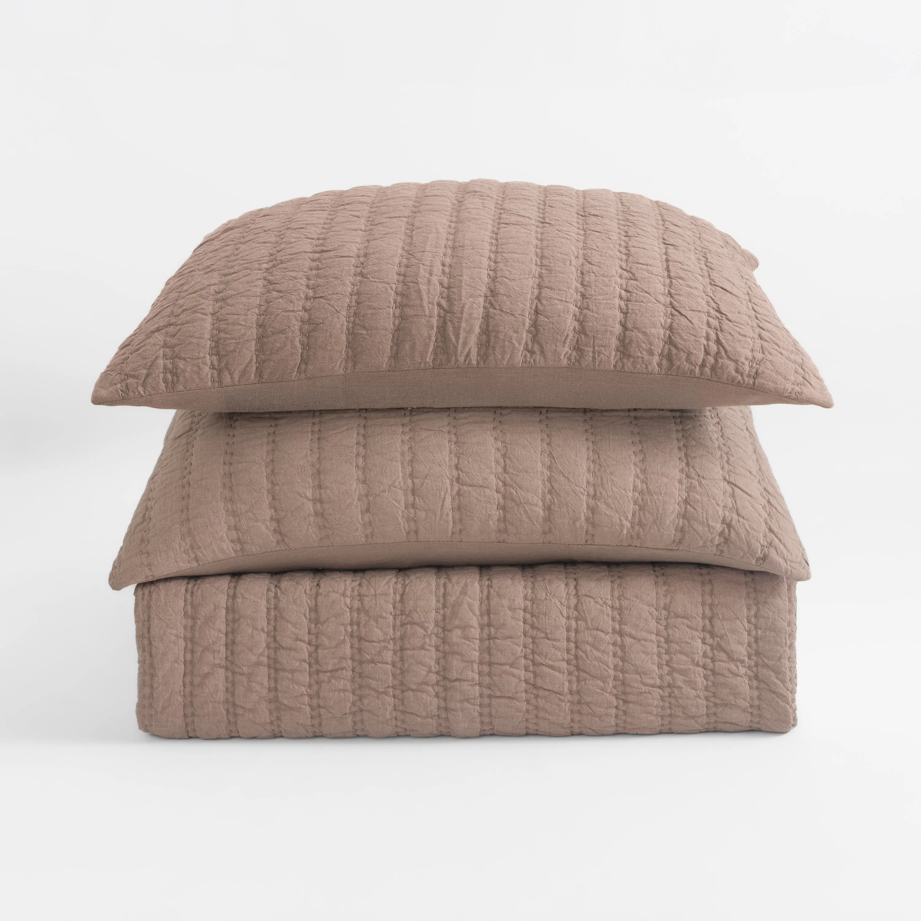 Cc1154tstk17 | Amity Home Close up of a quilted beige pillow stacked on other pillows against a white background showing textured stitching
