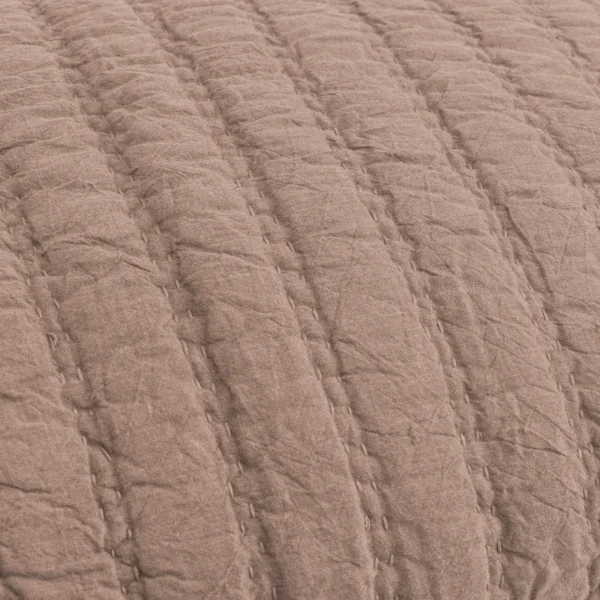 Close up of brown textured fabric with visible stitching and a wrinkled surface