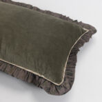 Close up of a soft olive green blanket with a brown camouflage patterned border folded along the edge