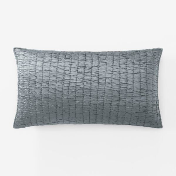 Close up of a gray quilted pillow occupying the bottom half of the frame against a white background showing a crinkled stitched texture