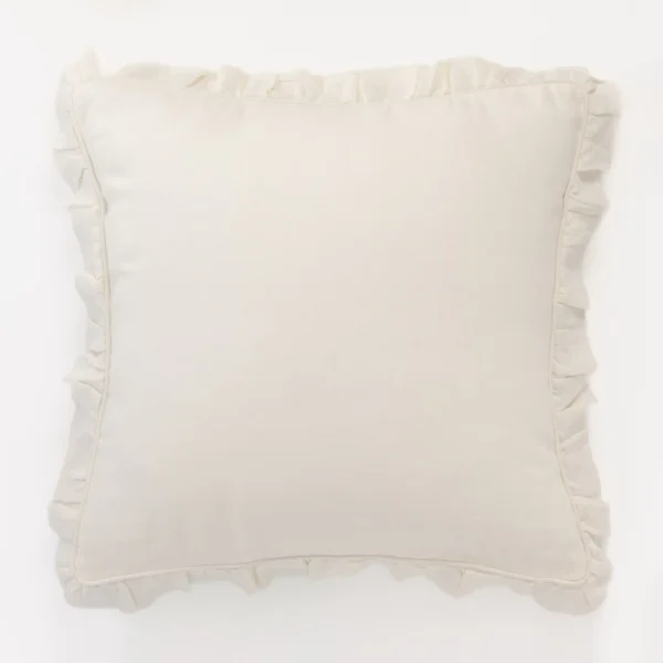 White pillow with ruffled edges set against a light background