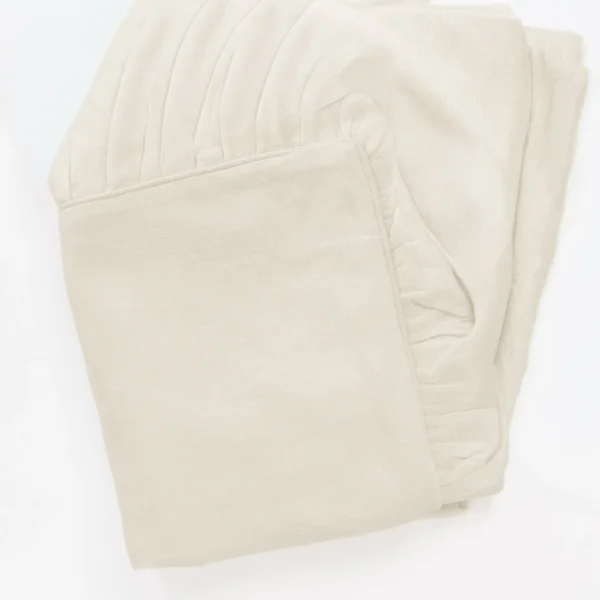 Beige folded knitted fabric with visible stitching details close up texture area