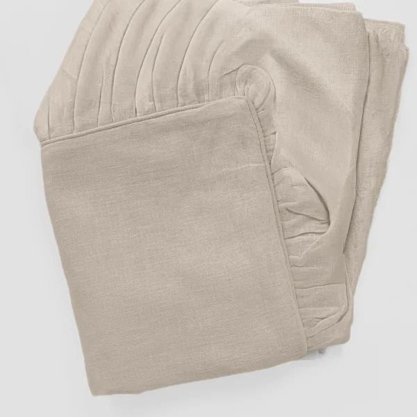 Beige folded textile with visible weave texture and stitched hems