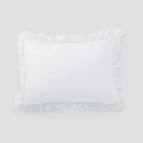White pillow with a ruffled edge resting on a light gray background close up view