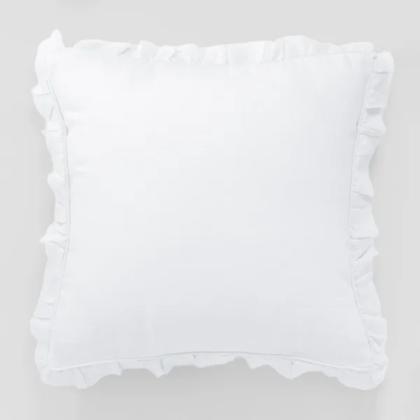 White pillow resting on a light gray background showing soft fabric and pleated edges