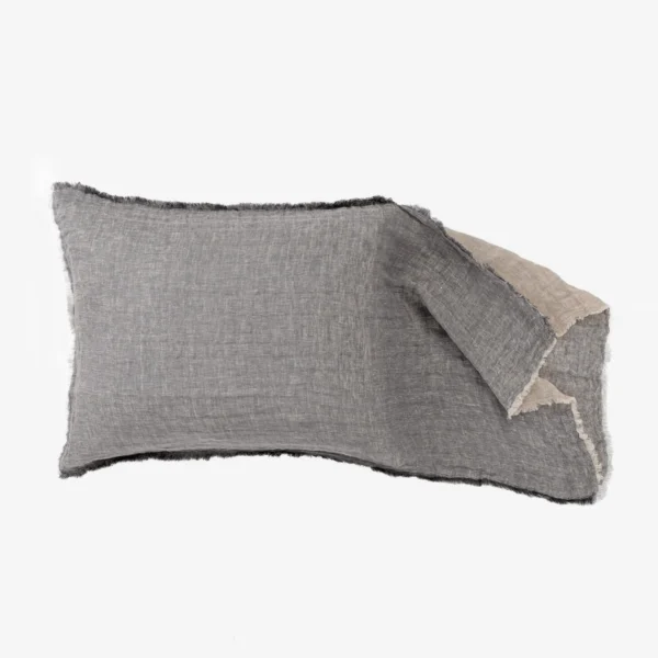 Rectangular pieces of frayed gray fabric overlapping on a white background resembling denim scraps