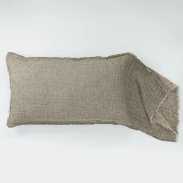 Beige linen fabric with frayed edges along the bottom of a white background