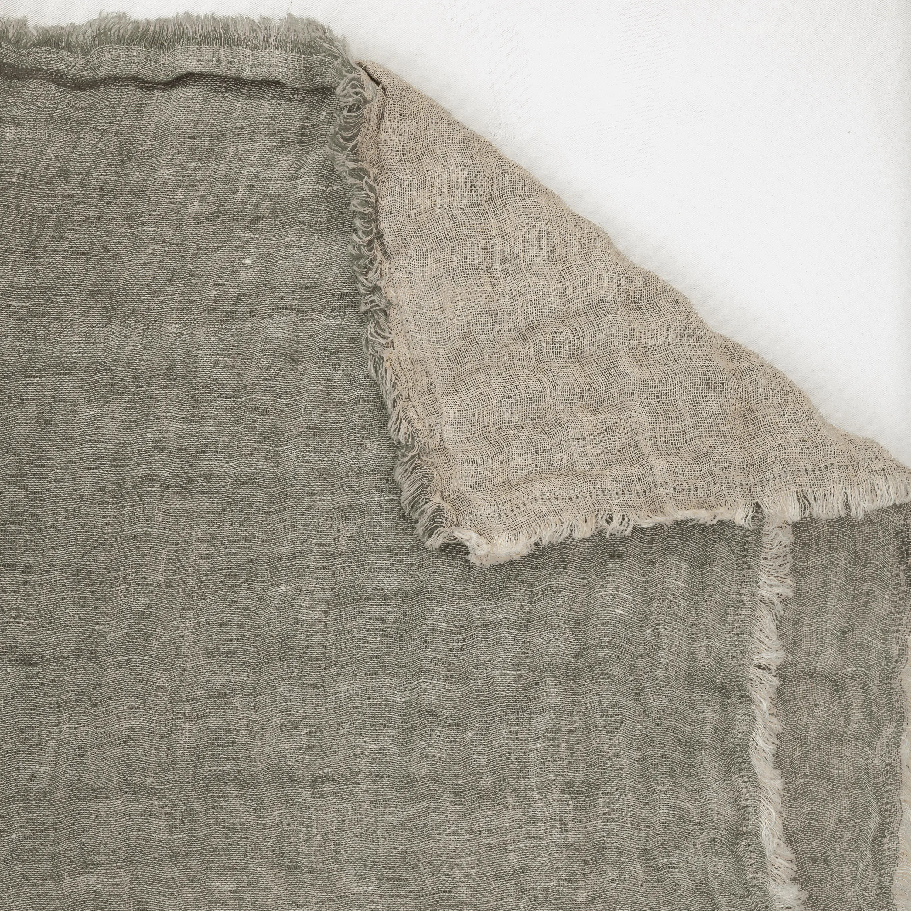 Cc926k7 | Amity Home Close up of coarse beige burlap fabric with frayed edges laid over another fabric showing woven texture and natural fibers