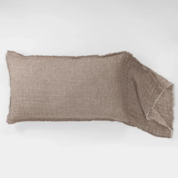 Beige linen cloth laid across the bottom of a white background with frayed edges
