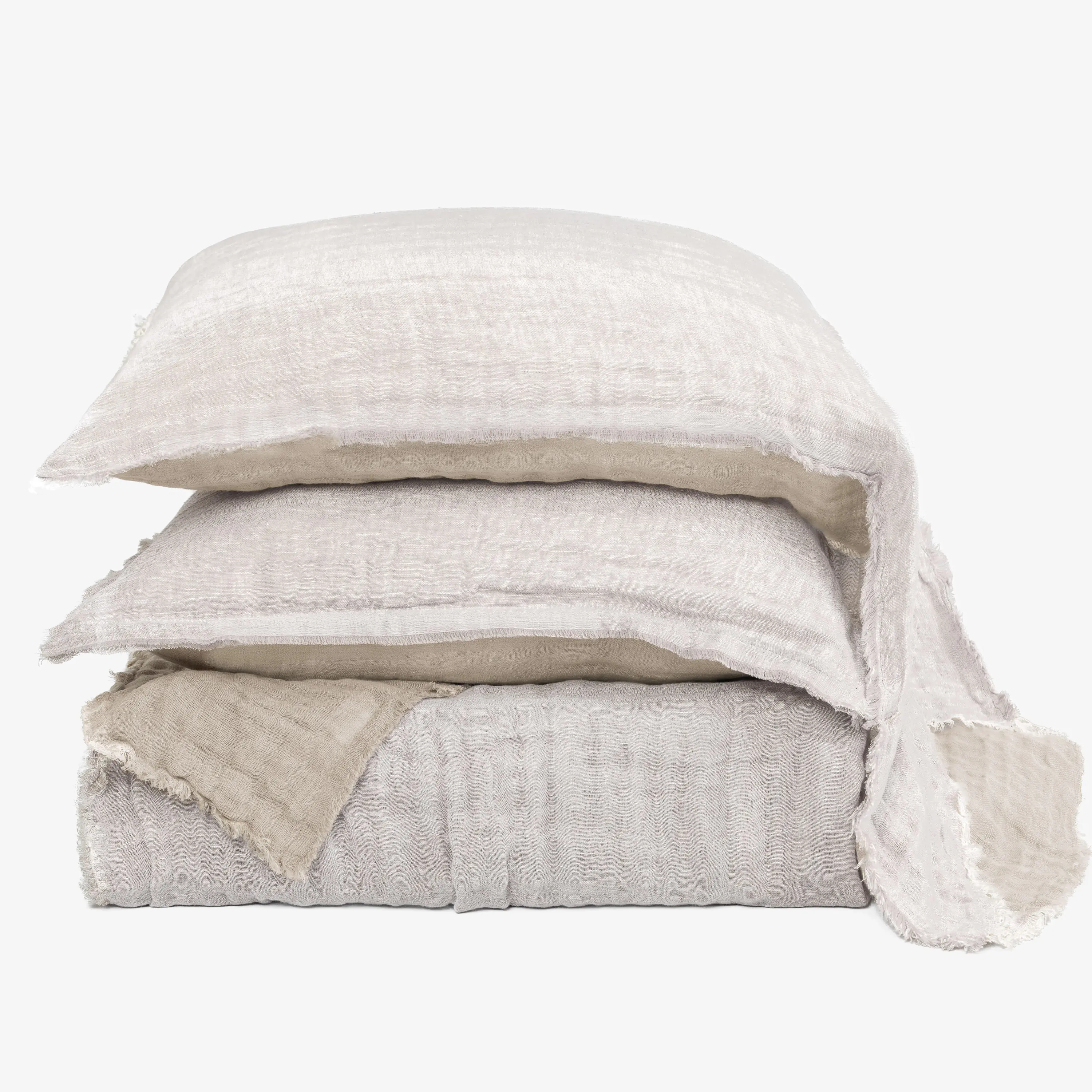 Cc926w31 | Amity Home Stack of beige linen throw pillows with frayed edges against a white background arranged in a tower