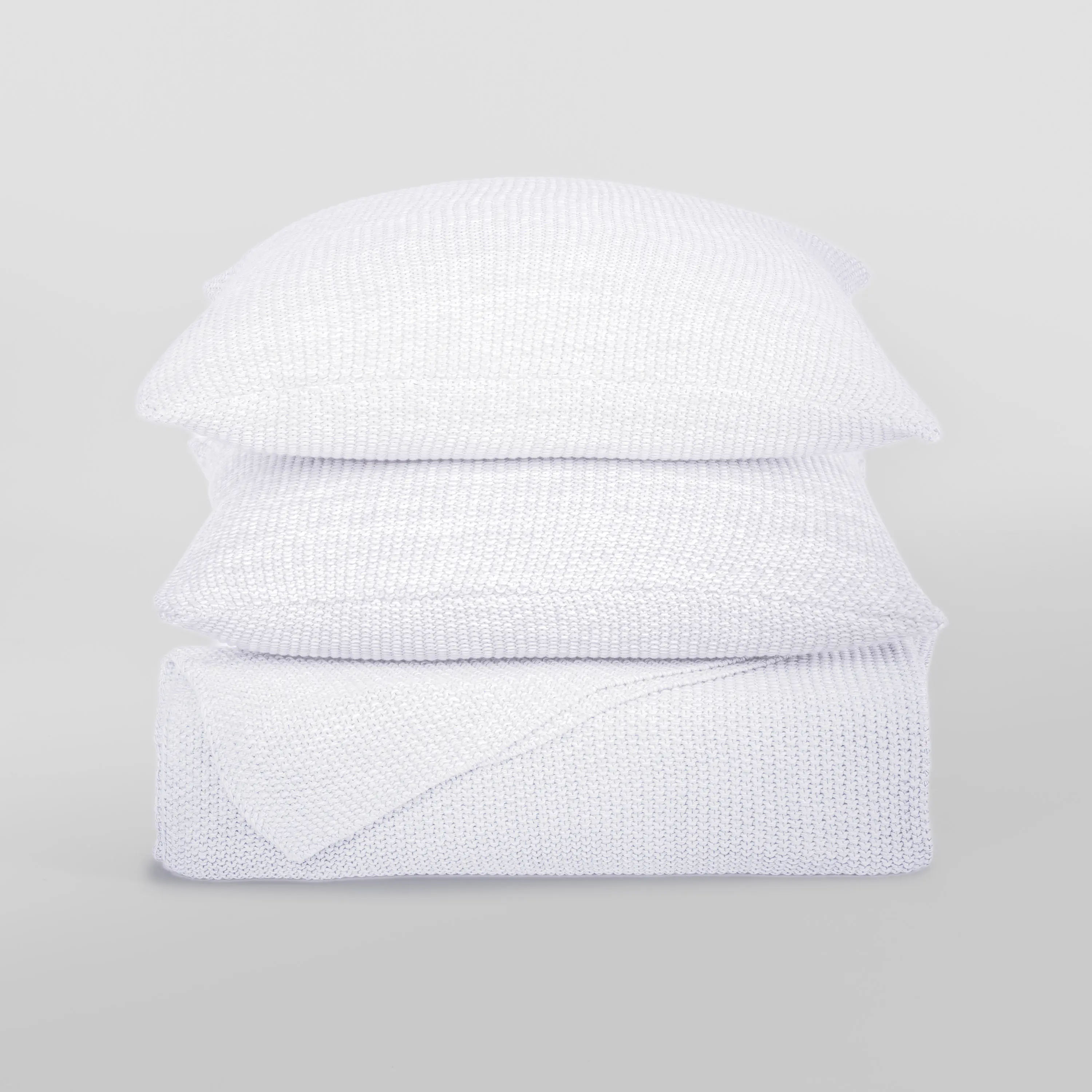 Kd2002w1 | Amity Home Stack of white knitted pillows stacked in a tall column against a light gray background showcasing textured fabric