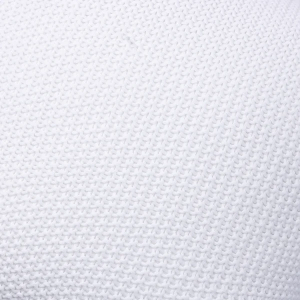 Close-up of white knitted fabric showing interlocking loop stitches with a soft texture.