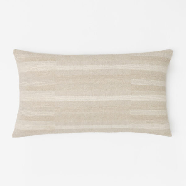 Beige striped pillow resting on a white surface showing soft textured fabric and curved edges at the bottom of the frame