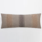 Brown woven decorative pillow with a dark vertical stripe along the center placed against a plain white background at the bottom edge of the frame