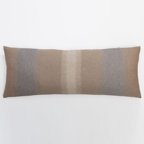 Partial view of a woven pillow with brown and beige stripes along the bottom edge against a white background decorative image