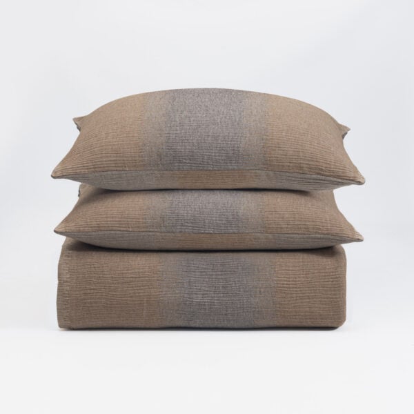 Three brown woven throw pillows stacked on a white background, showing textured fabric and seam details down the center.