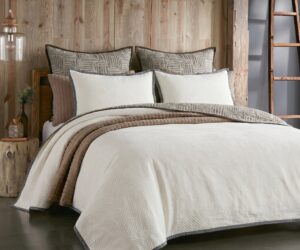 Rustic bedroom scene with a bed neutral bedding and a wooden paneled wall a ladder is visible on the right side