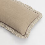 Two beige cushions with striped edges stacked on a white surface showing textured fabric and piping detail