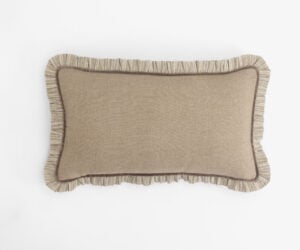 Beige throw pillow with striped ruffle trim along the bottom edge on a white background