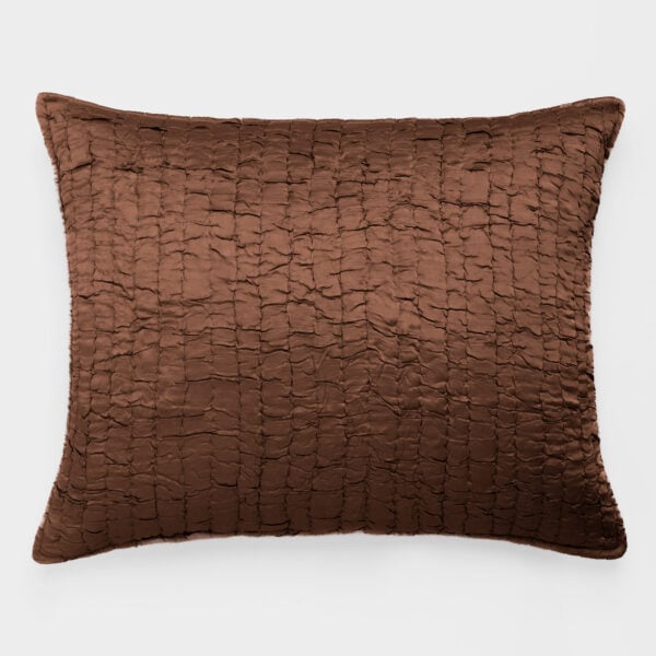 Brown quilted pillow with a textured, grid-like stitching on a white background.