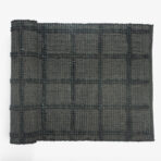 Close up of a dark woven textile with vertical beaded like patterns and raised stitches forming stripes
