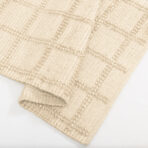 Close up of beige woven fabric with a tufted dotted pattern