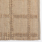 Close up of a beige woven fabric with chunky knobby yarn accents