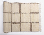 Beige woven rug with dark brown vertical stripes and fringe along the edge folded flat on a white background