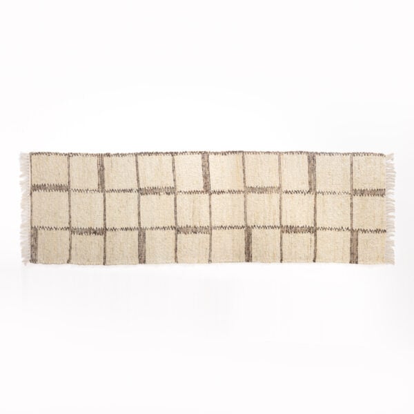 Beige woven rug with dark brown vertical stripes laid on a white background, fringed edges visible at sides.