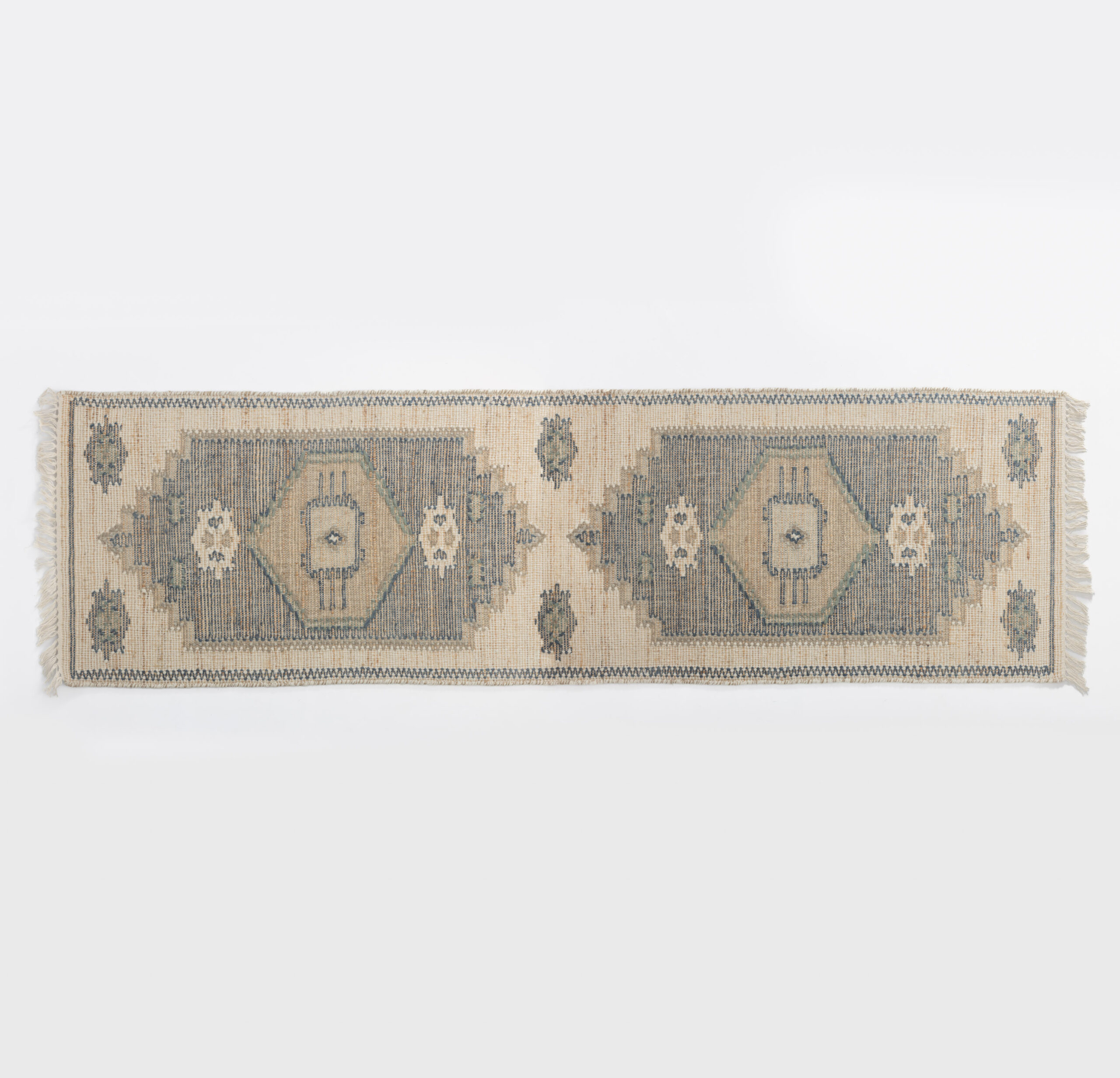 Rukc3012r8 32 | Amity Home Top down view of a vintage beige rug with blue geometric diamonds and fringed edges on a white background