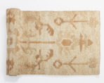 Close up of a beige woven rug with a subtle tan geometric pattern