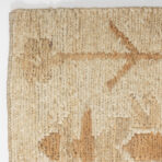 Close up of a beige braided jute rug showing thick woven strands and natural fiber texture