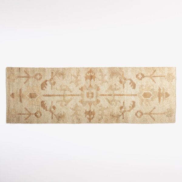 Close-up of a beige woven rug edge against a white background.