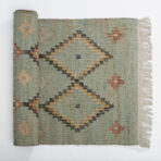 Teal woven rug with geometric diamond and zigzag patterns in yellow ivory and black fringed along the right edge