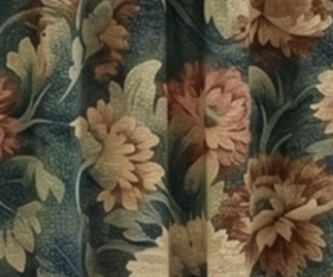Close up of teal fabric with large peach floral pattern and green leaves like vintage upholstery or curtain fabric