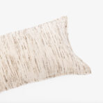 Close up of a beige striped fabric edge against a white background showing textured weave typical of a cushion cover