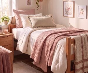 Cozy pink themed bedroom with two single beds pink quilts and string lights above