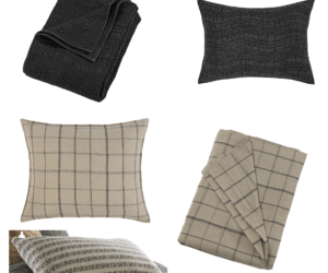 Assorted home textiles on a white background black quilted blanket black textured cushion and beige plaid pillows and blankets folded nearby