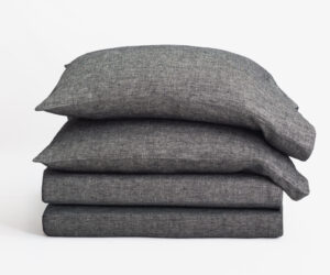 Stack of gray fabric pillows on a white background arranged in a neat pile