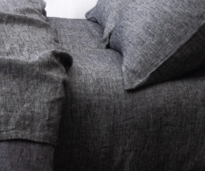 Close up of gray linen fabric with visible weave and soft folds