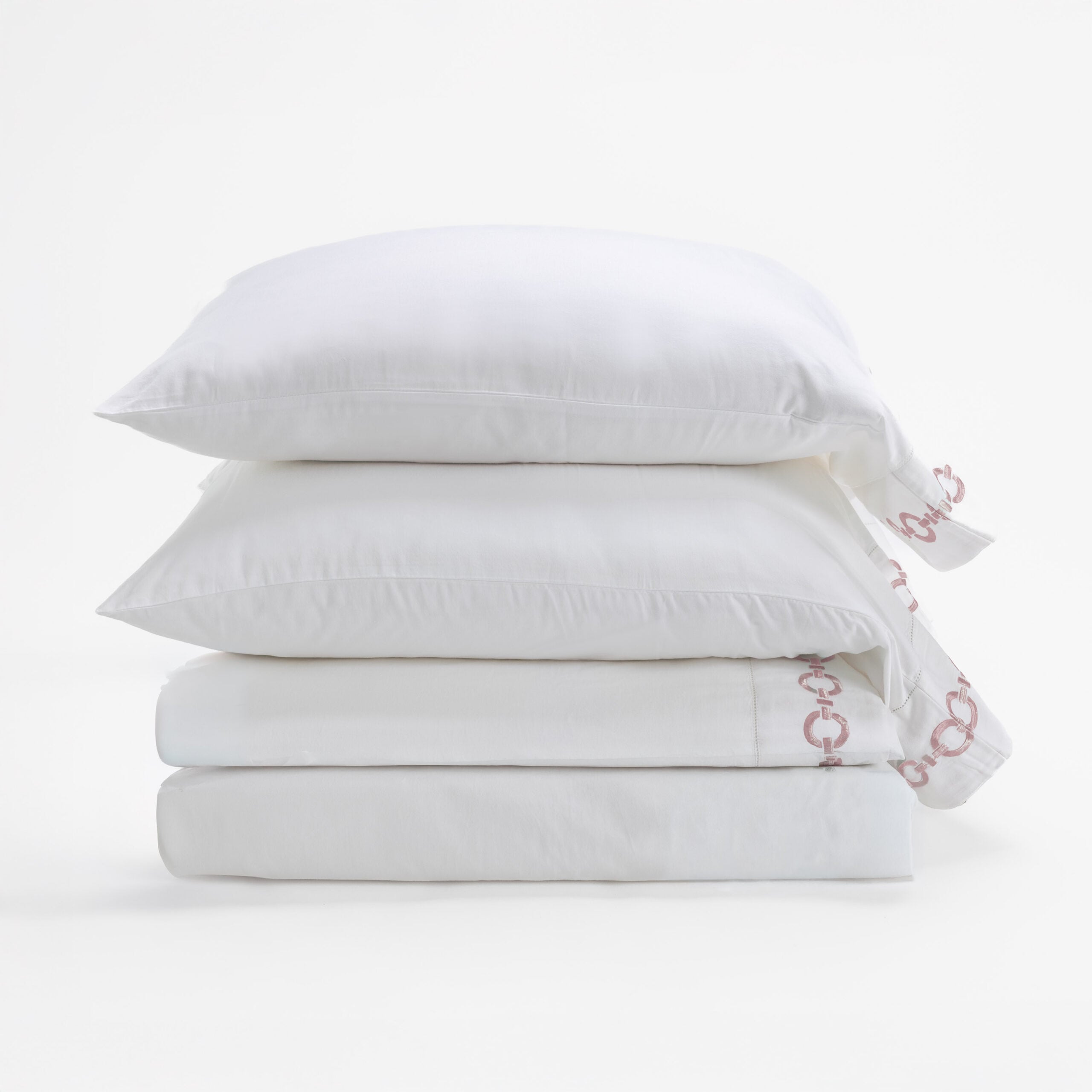 17201p 43 | Amity Home Stack of white pillows with smooth pillowcases arranged in a neat tower on a white background with a hint of pink pattern on the edge of the fabric on the right side