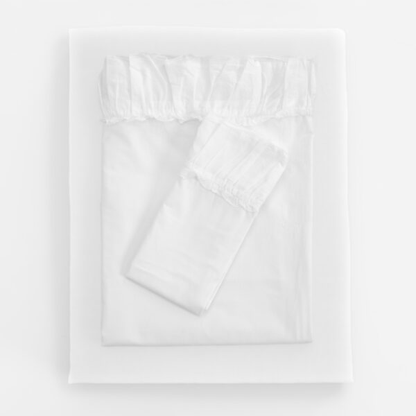 Top down view of a neatly made bed with white sheets and a pillow
