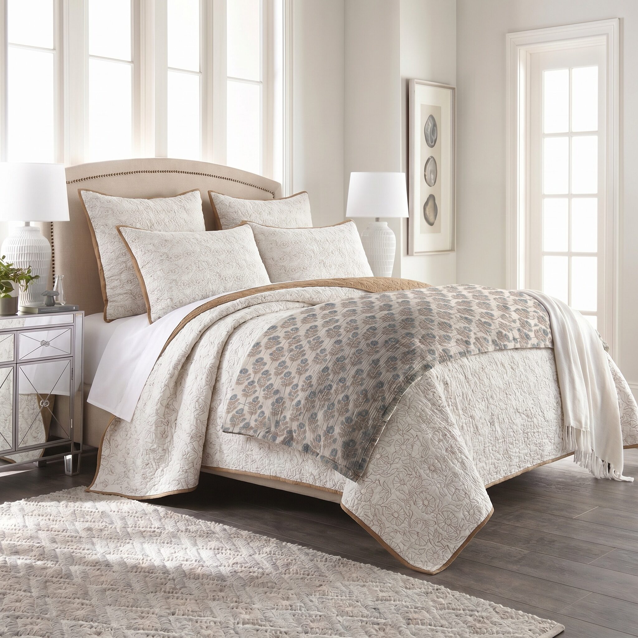 Asha Bed Pouf | Amity Home Cream quilted bedding on a tufted headboard bed with decorative pillows in a bright neutral bedroom with large windows