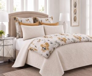 Beige upholstered bed with floral and solid mustard pillows white quilted cover in a sunlit neutral bedroom