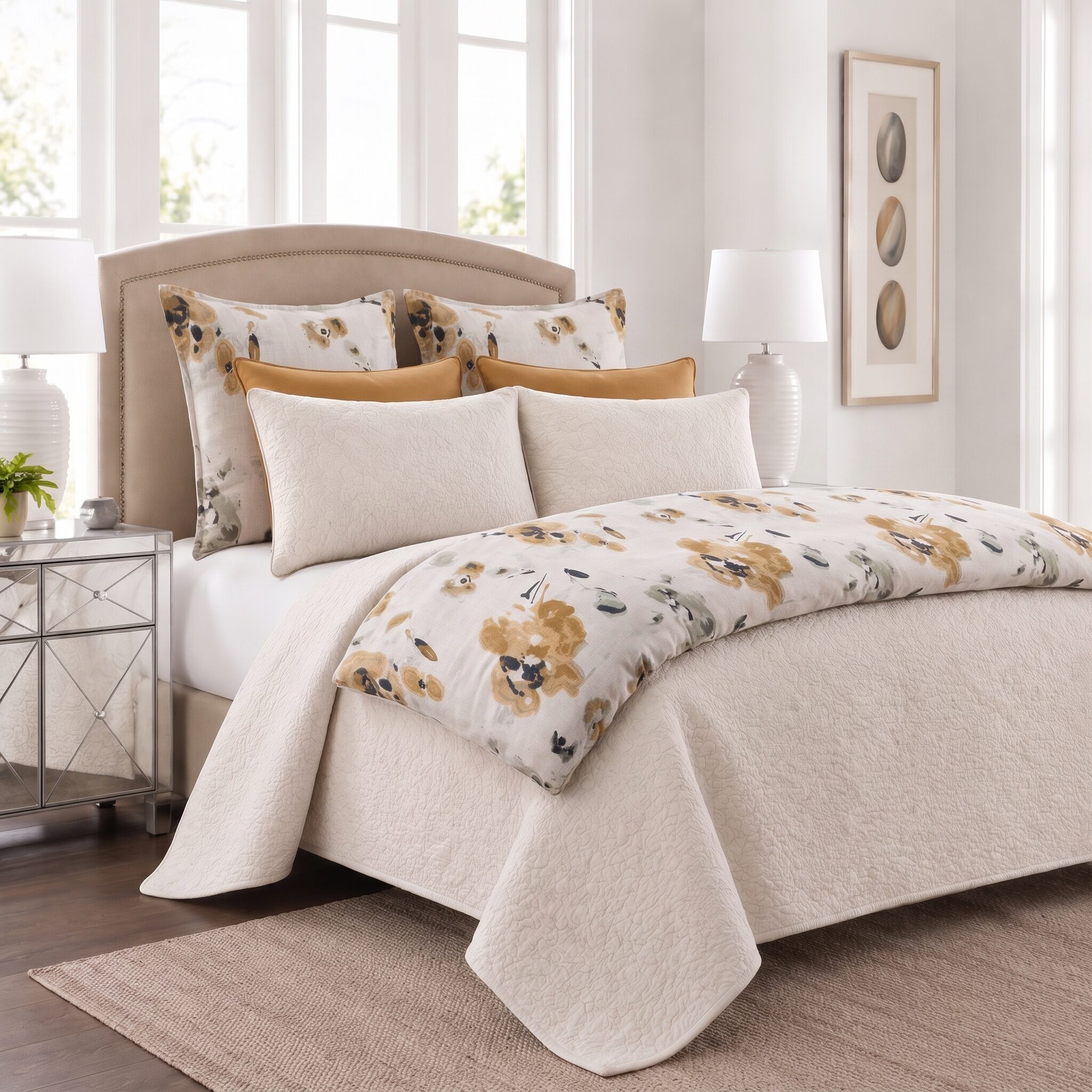 Casteel Ochre Bed Pouf | Amity Home Beige upholstered bed with floral and solid mustard pillows white quilted cover in a sunlit neutral bedroom