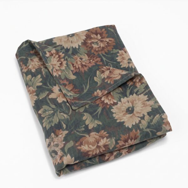 Folded fabric with a beige and brown floral pattern on a dark green background
