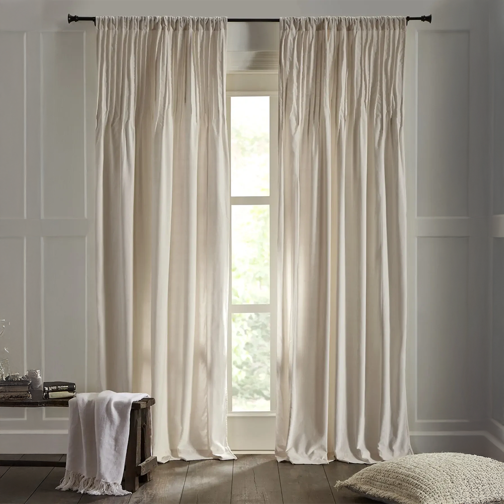 Cm630e | Amity Home White flowing curtains framing a tall window in a sunlit bedroom with a wooden bench and cozy rug nearby
